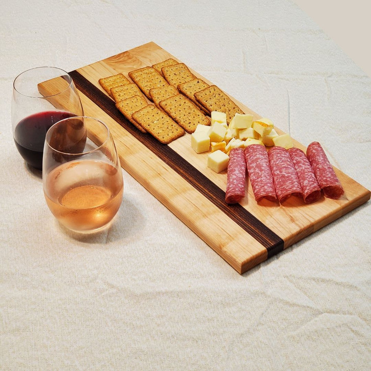 Solid maple and zebrawood cutting board with charcuterie and wine