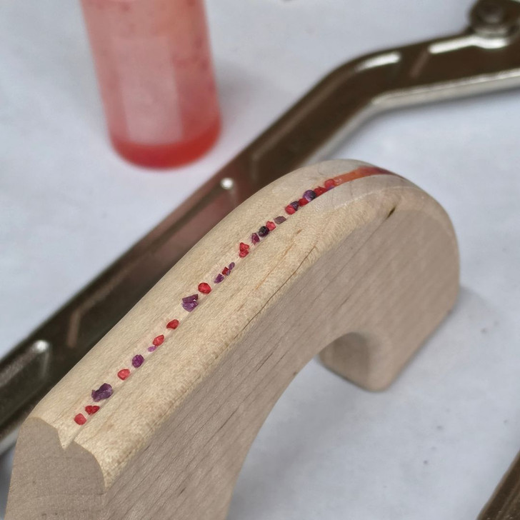 rubies and crushed glass being placed for the ruby inlay horizontal single fishing rod rack