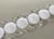 Image of a strip of 1 3/8'' White Soft Loop Coins with Acrylic 72 Adhesive VELCRO® Brand Hook and Loop Fasteners available at iTapeStore.com