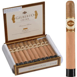 Gilberto Oliva Reserva Blanc Cigars Corona 20 Ct. Box 5.75X43, open wooden box containing 20 cigars with a light brown wrapper and gold accents, alongside a single cigar for close-up viewing. Gilberto Oliva Reserva Blanc Cigars Corona 20 Ct. Box 5.75X43, open wooden box containing 20 cigars with a light brown wrapper and gold accents, alongside a single cigar for close-up viewing.