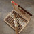 AJ Fernandez Ave Maria St. George Cigars 20Ct. Box, open wooden box of cigars with one cigar outside, showcasing premium cigars with intricate band designs.