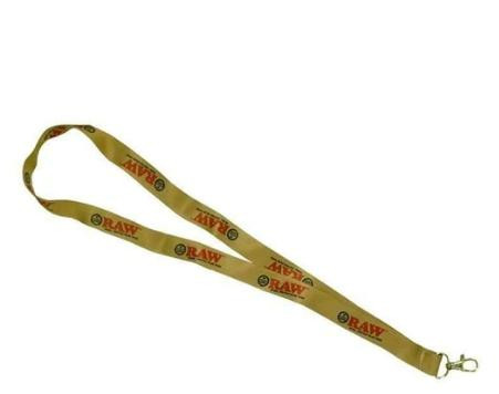 RAW Lanyard, a beige fabric lanyard with 'RAW' logo printed repeatedly in red and black, featuring a metal clip at the end for attaching identification cards or keys.
