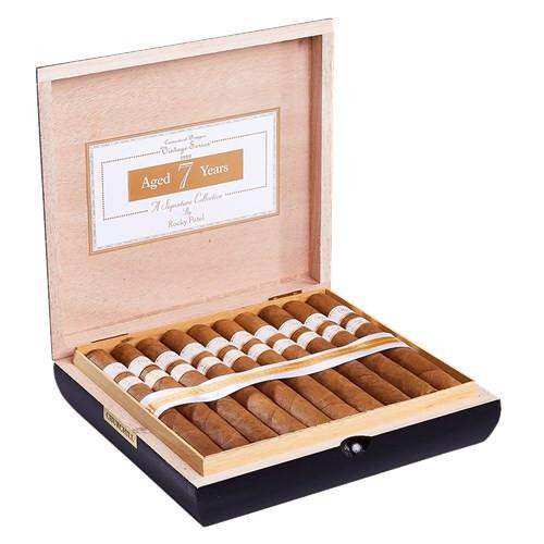 Rocky Patel Vintage 1999 Connecticut Cigars, open wooden box containing neatly arranged cigars with white bands, inside a framed label indicating 7 years aging.
