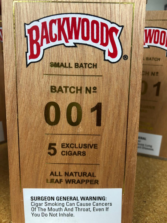 Altadis Backwoods Small Batch 001 (Gold Edition), cigar packaging with a woodgrain design, featuring red and white logo, golden text, and warning label.