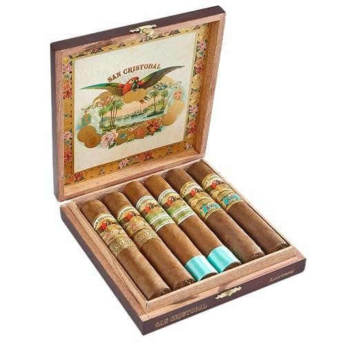 San Cristobal 60-Ring Cigars Sampler 6Ct, open wooden box displaying six cigars with colorful bands, inside a decorative interior with tropical scene artwork.