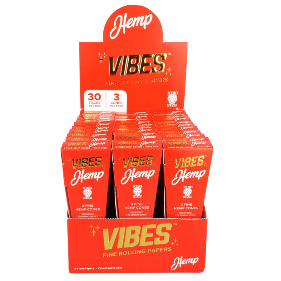 Vibes Rolling Paper VIBES Hemp Cones Kingsize Slim 30/3Ct, display of multiple red boxes of hemp cones with white and gold text, arranged in a stand.