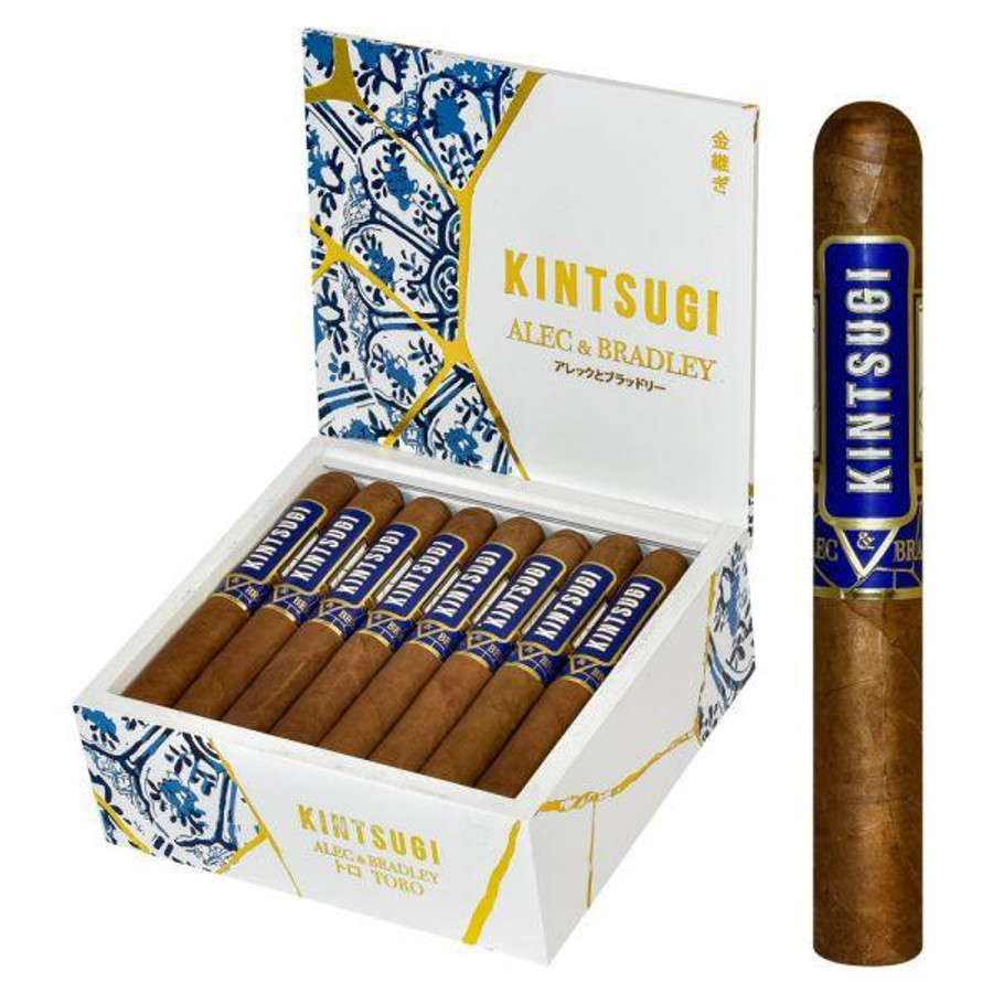 Alec Bradley Alec & Bradley Kintsugi Toro Cigars 24Ct. Box, featuring a white box with gold and blue accents containing 24 cigars, with one cigar shown outside the box displaying a blue and gold band.