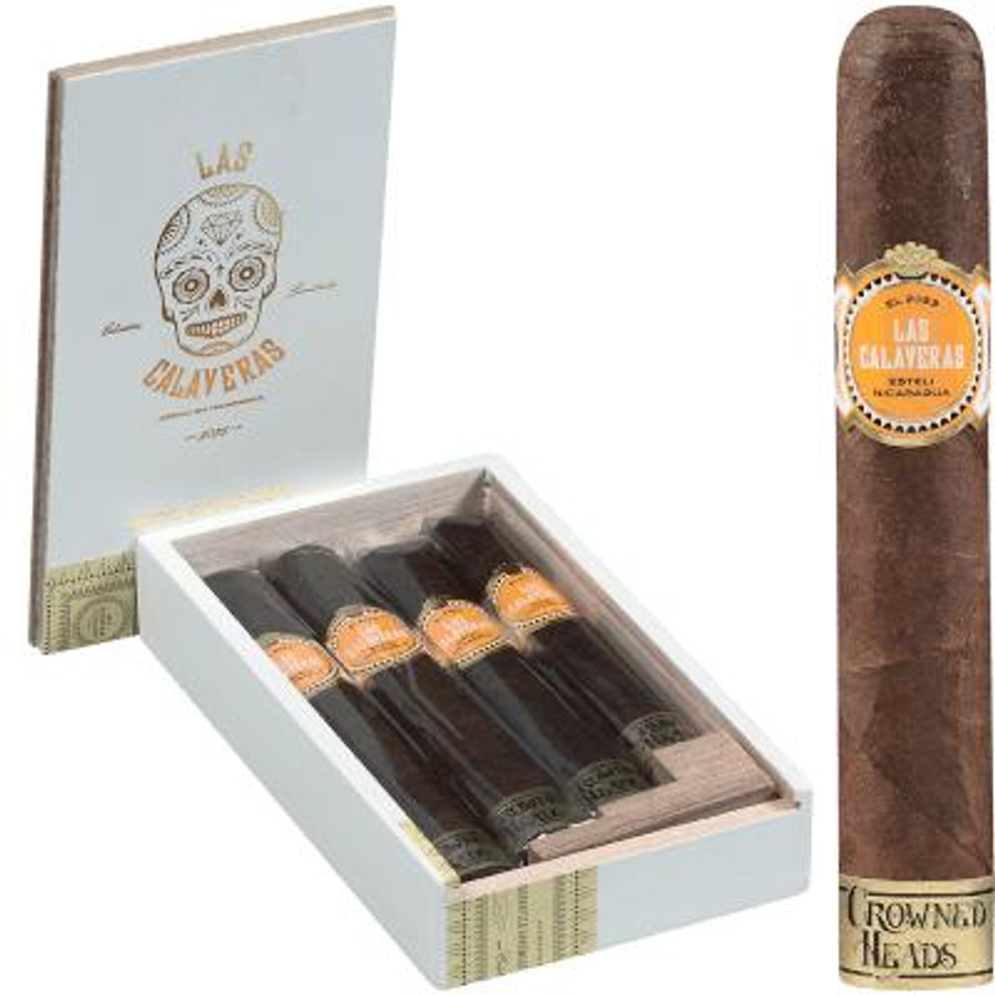 Montecristo Crowned Heads Las Calaveras Cigar Sampler 2023 Collection 4ct, a set of four premium cigars in a white box with a lid featuring a skull illustration and the collection name, with one cigar standing upright beside the box showing its detailed band.