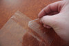 Peeling the backing material exposes the adhesive strip.