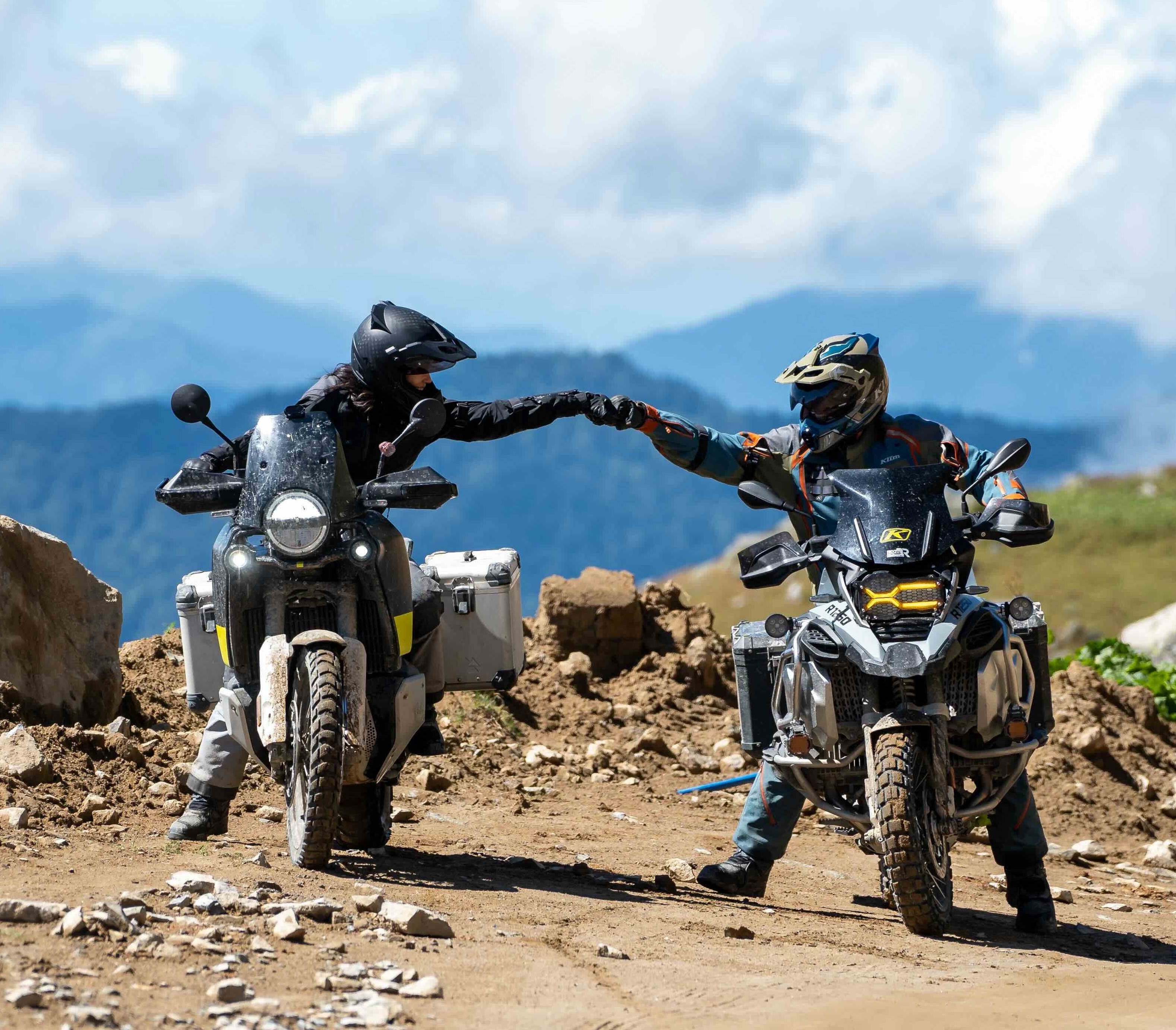 Adventure motorcyclists pounding knuckles