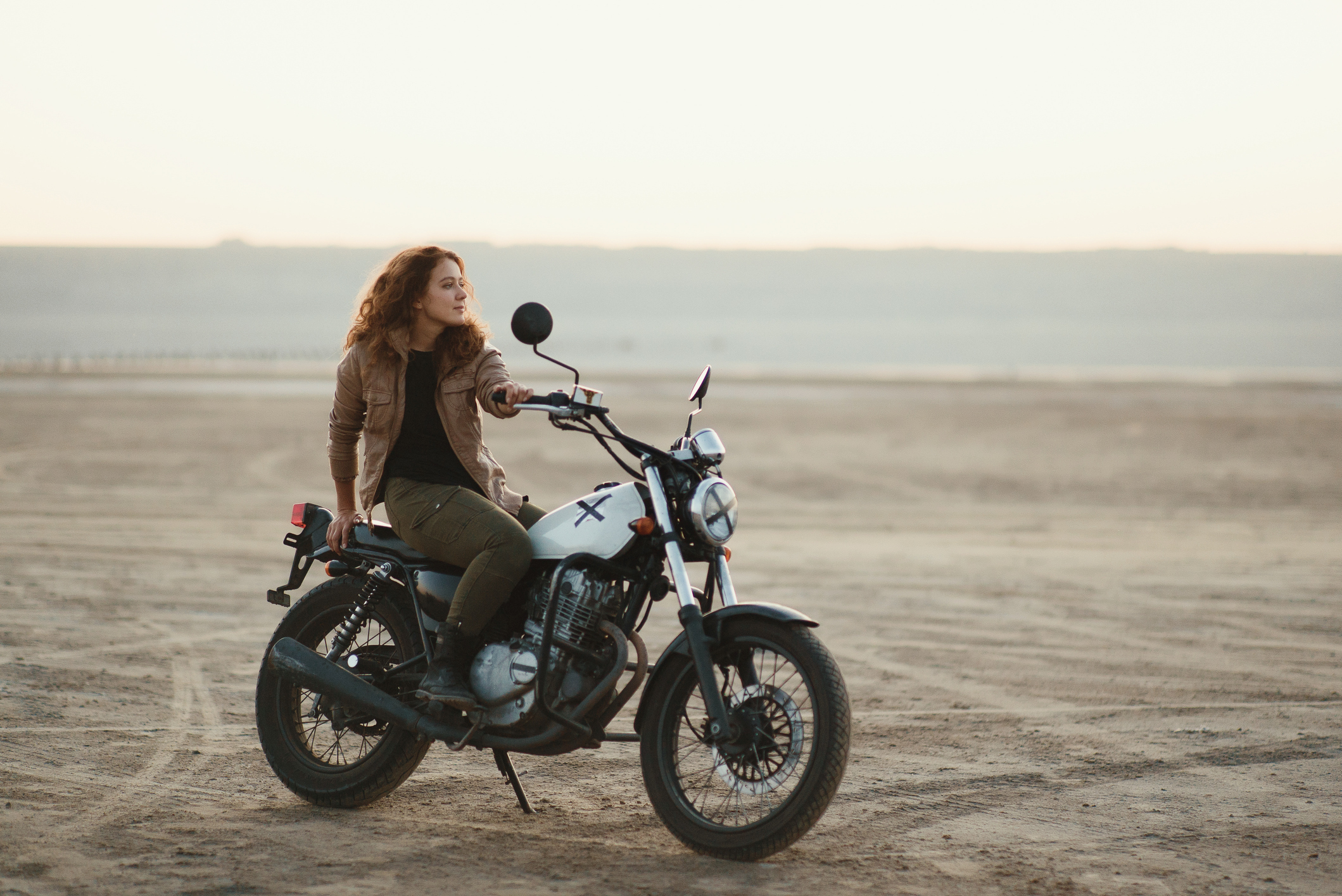 woman along in a dirt area on a motorcycle