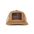 A tan trucker-style snapback hat featuring a structured canvas front and white mesh back. The front panel displays a rectangular faux leather patch engraved with the American flag and United Kennel Club logo. A tan trucker-style snapback hat featuring a structured canvas front and white mesh back. The front panel displays a rectangular faux leather patch engraved with the American flag and United Kennel Club logo.