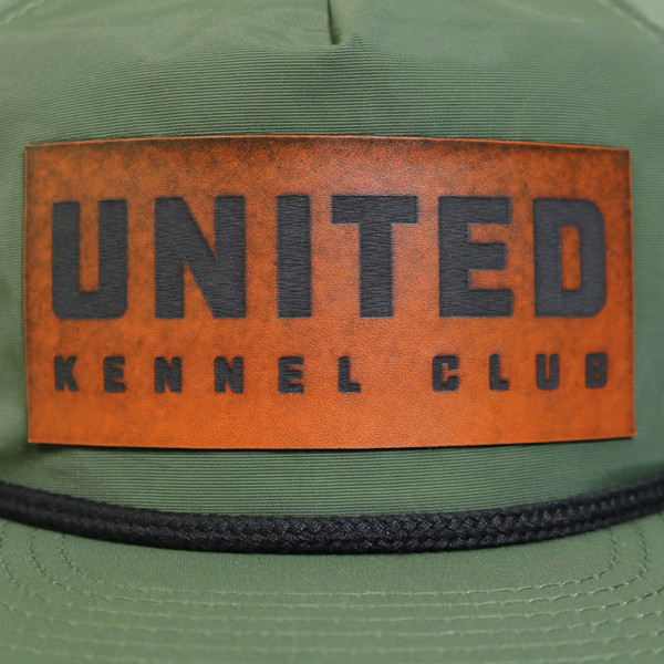 Green ripstop flat bill hat with rope detail, featuring a faux leather United Kennel Club logo patch on the front. Water-resistant, UPF 50+, and made with a recycled plastic bill. Green ripstop flat bill hat with rope detail, featuring a faux leather United Kennel Club logo patch on the front. Water-resistant, UPF 50+, and made with a recycled plastic bill.