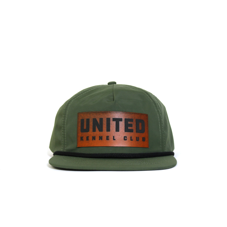 Green ripstop flat bill hat with rope detail, featuring a faux leather United Kennel Club logo patch on the front. Water-resistant, UPF 50+, and made with a recycled plastic bill.