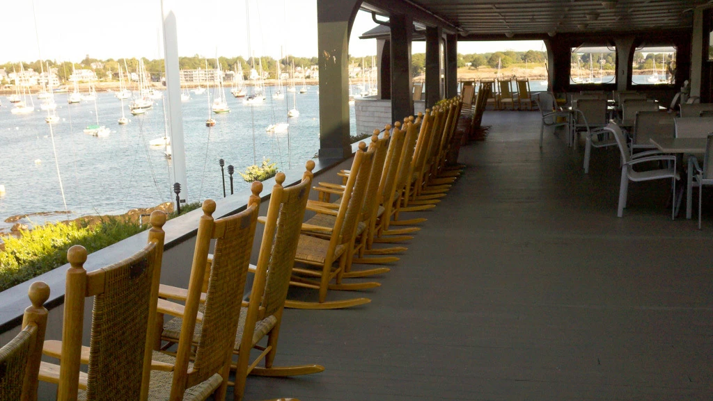 Coordinated row of solid wood Troutman rocking chairs at a waterfront gathering space