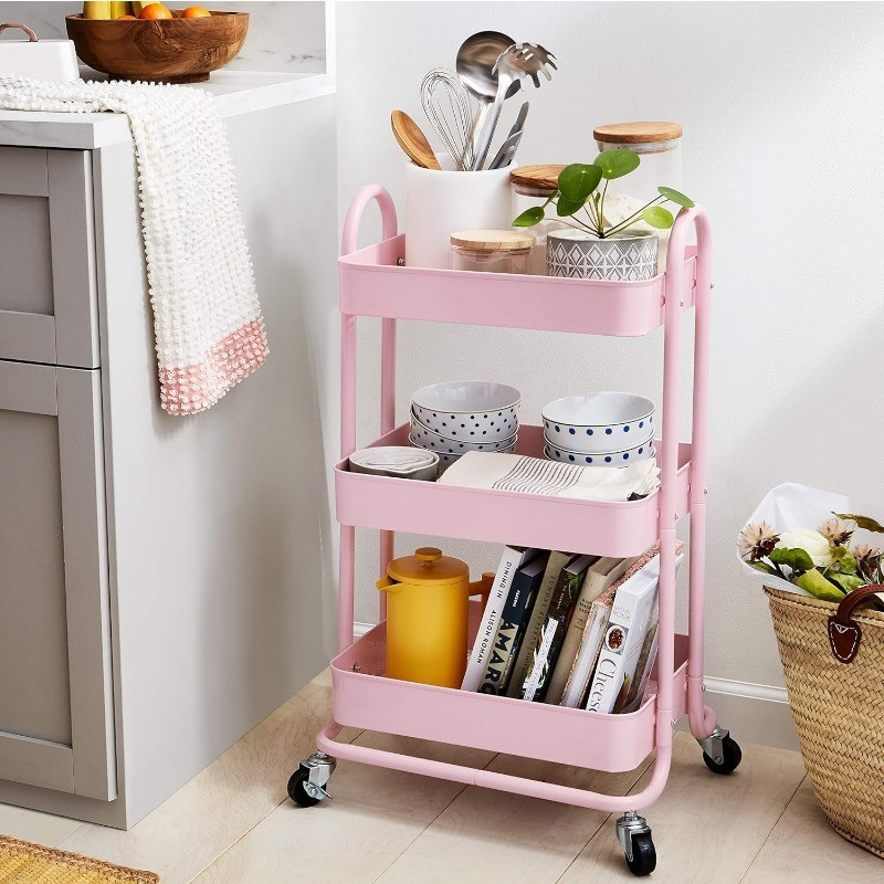 Pink three-tier rolling metal storage cart in kitchen setting