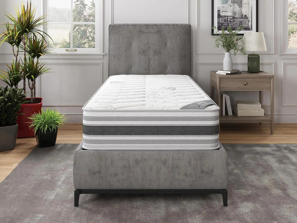 Twin mattress on a gray bed in a showroom-like room