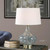 BOWERY HILL Contemporary Table Lamp, Blue Gray Glass with Brass Accents, 24.75 in Height, Ivory Linen Shade, Slightly Tapered Hardback, Indoor Use