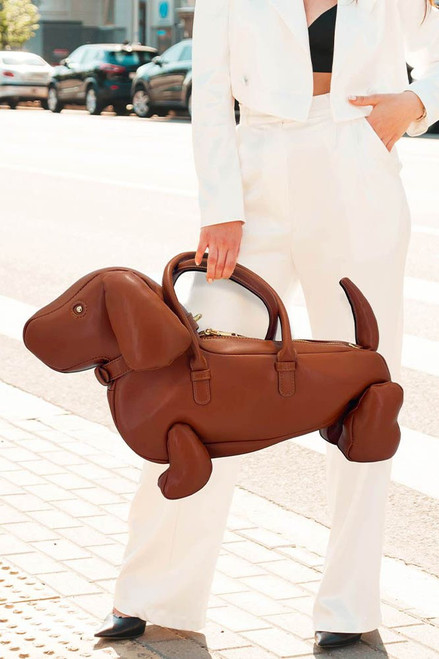 Size : 18" X 12" X 9" Top Handle Size : 5.5" L Strap Size : 52" L / Detachable, Adjustable One Inside Zipper Pocket Zipper Closure Eye-catching dachshund shaped statement handbag designed to turn heads and spark conversation. Spacious interior with secure closure and top handles for easy carry. Perfect for fashion-forward boutiques, themed collections, and customers seeking a playful, standout accessory. Faux Leather Dachshund Dog Crossbody Handbag