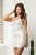 Adorable white silver sequins cocktail dress with plunging V neckline and lace up back in style NX R761. Shop Prom Avenue 

Available in Silver as Shown 