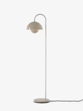 A grey/beige floor lamp with a rounded shade, where a slender curved stem in chrome attaches to the grey/beige base. Designed by Verner Panton