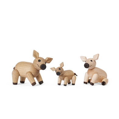 Set of three wooden pig figurines on a white background