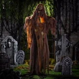 Product A Holiday Company Light-Up 5 Ft. 2" Standing Skeleton Reaper with Chains & Sound Halloween Decoration, spooky Halloween skeleton reaper figure with chains and glowing lights in a graveyard scene.
