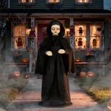 Morris Animated 5 FT Light-Up LED Standing Doll with Moving Head & Eyes, Halloween decoration featuring a spooky doll in a black hooded cloak with glowing eyes in front of a haunted house decorated for Halloween.