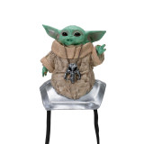 JazWares Star Wars™ The Mandalorian™ Grogu™ Shoulder Sitter, a cute collectible figurine of Grogu from Star Wars, wearing a beige robe and a necklace with a skull pendant, with large ears and expressive eyes.