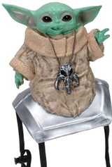 JazWares Star Wars™ The Mandalorian™ Grogu™ Shoulder Sitter, a cute figurine of Grogu (Baby Yoda) with large black eyes, green skin, wearing a beige robe with a skull necklace, sitting on a silver platform with black feet.