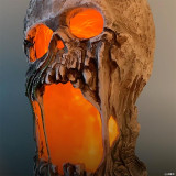 Morris 12" Flaming Rotted Skull Animated Prop, a detailed skull sculpture with a flaming, rotted appearance and glowing orange light inside.