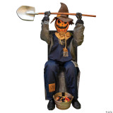 Morris Smiling Jack Greeter With Chair, a Halloween decoration featuring a scarecrow with a pumpkin head, smiling face, and holding a shovel while sitting on a chair with a bucket of pumpkins and gourds at its feet.