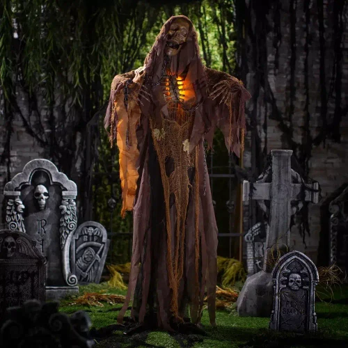 Product A Holiday Company Light-Up 5 Ft. 2" Standing Skeleton Reaper with Chains & Sound Halloween Decoration, spooky Halloween skeleton reaper figure with chains and glowing lights in a graveyard scene.