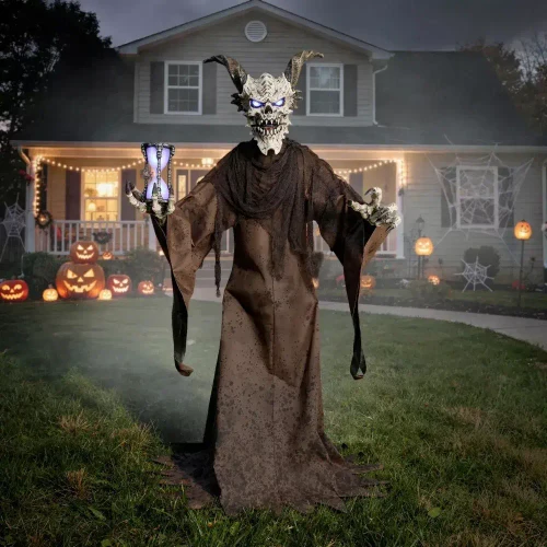 Morris Animated 7 Ft. 9" Light-Up The Time Demon Halloween Decoration, a tall, fearsome demon figure with a skull face, horns, glowing eyes, and outstretched clawed hands, standing in a haunted house yard decorated for Halloween.