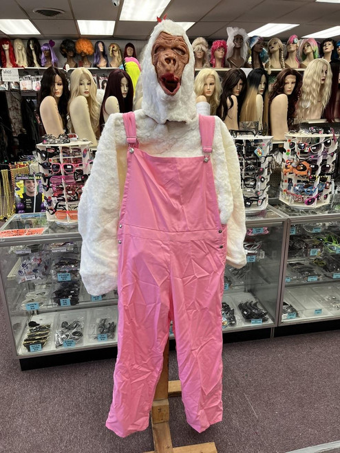 Fantasy Costumes Gorilla Mascot Costume - Pink & White Overalls, in a costume store among wig and hat display