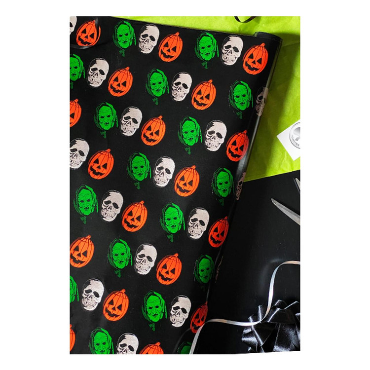 Trick or Treat Studios Halloween III Wrapping Paper, Halloween-themed wrapping paper with skulls, pumpkins, and faces in orange, green, and white on black background.