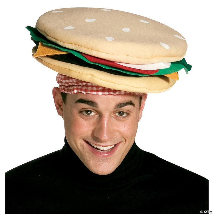 Rasta Imposta Cheeseburger Hat - New, a humorous plush hat designed to look like a cheeseburger with buns, lettuce, tomato, cheese, and other burger ingredients, worn by a smiling man in a black turtleneck.
