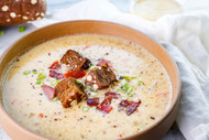 Beer Cheese Soup with Crispy Bacon, Green Onions, and Dark Rye Croutons