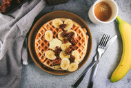 Greek Yogurt Waffles with Bananas, Candied Pecans, Maple Rum Syrup and Whipped Cream