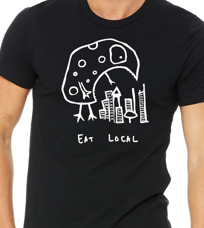 Close-up of Eat Local kaiju monster illustration over city buildings on graphic tee
