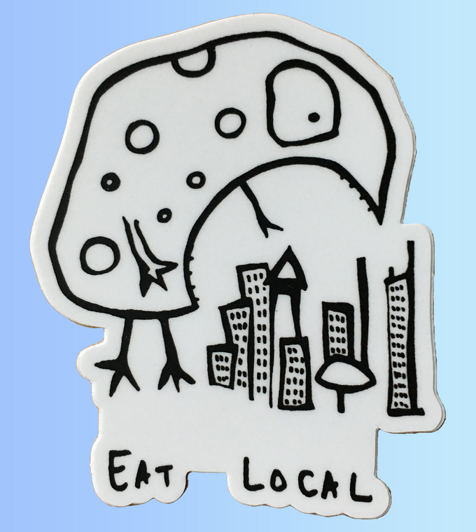 A black and white cartoon creature standing over a small city with the words “Eat Local” written below.