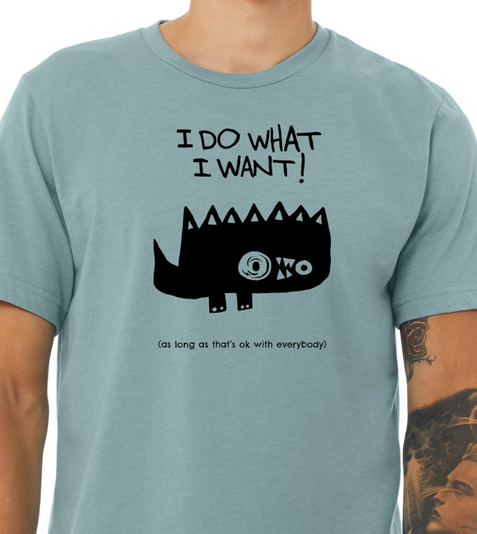 Close-up of spiky cartoon monster illustration with humorous polite rebellion quote on blue tee.