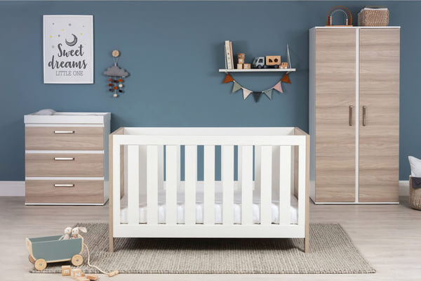 room filled with white cot and brown/white cupboard/chest of drawers