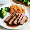 Sliced flank steak meal with red wine mushroom sauce, mashed sweet potatoes, and roasted broccoli.