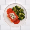 Cheesy vegetable lasagna dinner served with seasoned roasted broccoli.