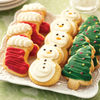 Assortment of hand-frosted holiday sugar cookies featuring decorated Christmas trees, snowmen, and stocking designs