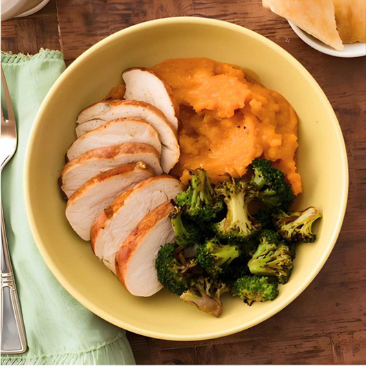 Roast turkey breast dinner with turkey gravy, mashed sweet potatoes, and roasted broccoli.