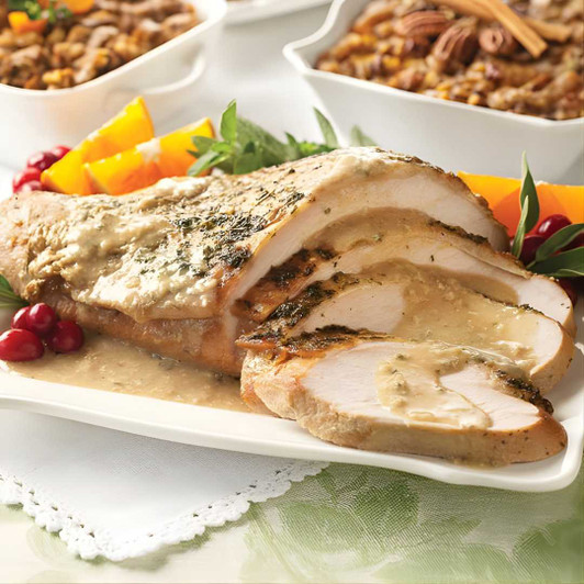 Fully cooked, seasoned roast turkey breast sliced on a platter served with rich homestyle turkey gravy - SendaMeal.com