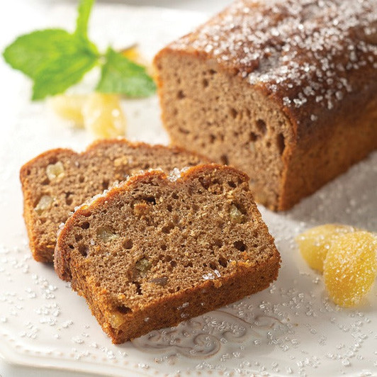 Gingerbread loaf cake with two slices arranged on a white platter.