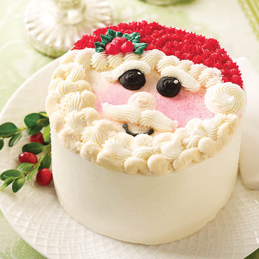 Jolly Santa vanilla cake decorated with a red hat, white buttercream beard and rosy cheeks.